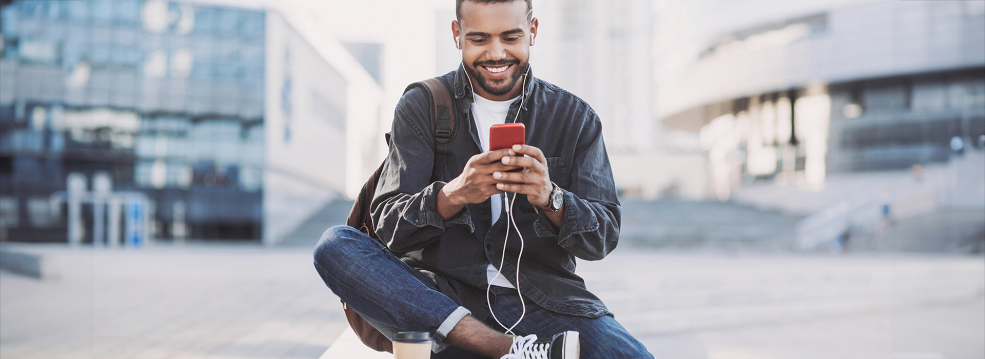 Man looking at phone sitting outside